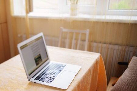 Laptop with white screen on marble table.の写真素材
