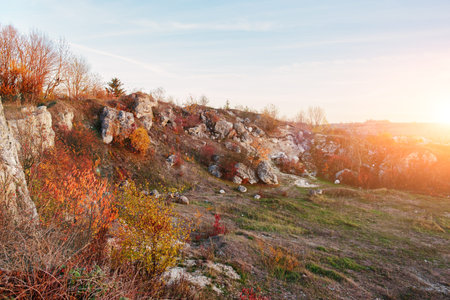 View on the beautiful colorful autumn landscape of the hills with trees, rocks and greenfields in the countryside.の写真素材