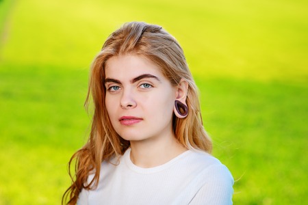 Portrait of a young beautiful woman with wooden tunnels in her ears.の写真素材