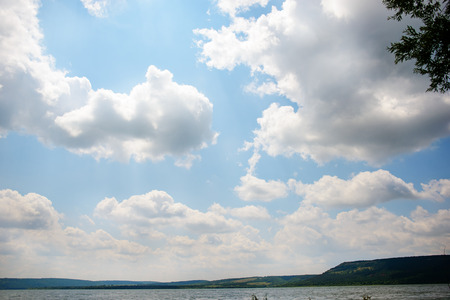 beautiful lake landscape with mountains, green forests, bright and sunny skies with clouds.の写真素材
