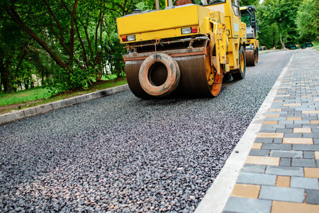 Carrying out repair works: asphalt roller stacking and pressing hot lay of asphalt. Machine...