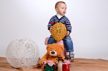 little boy playing with yarn balls on a white background, Studioの写真素材