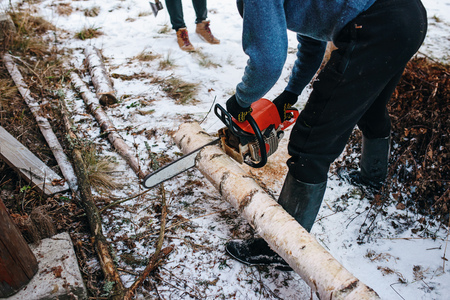 Process of sawing log by chainsaw in the winter .の写真素材