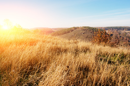 View on the beautiful colorful autumn landscape of the hills and greenfields with trees and grass upon the countryside.の写真素材