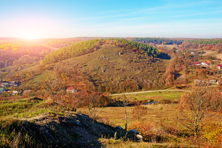 View on the beautiful colorful autumn landscape of the hills with trees and greenfields in the countryside.の写真素材
