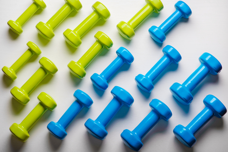 many blue and green dumbbells on a white background ,concept preparing to fitness sports equipment top view mock up.の写真素材