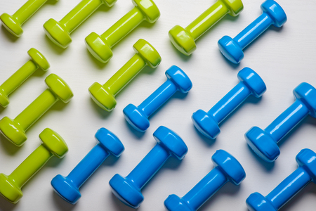 many blue and green dumbbells on a white background ,concept preparing to fitness sports equipment top view mock up.の写真素材