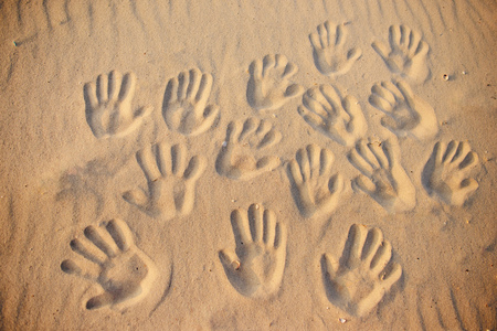 lots of hand prints on the sand.の写真素材