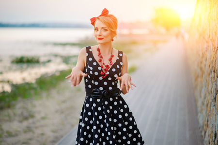 A girl in a dress is dancing happily in the outside.の写真素材