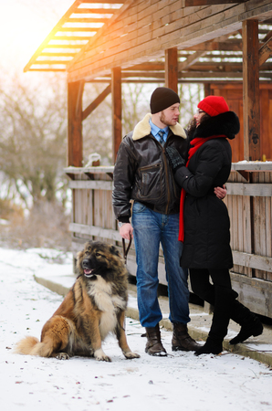 Happy couple with dogs in winter forest. Lovely moments outdoor holidays.の写真素材