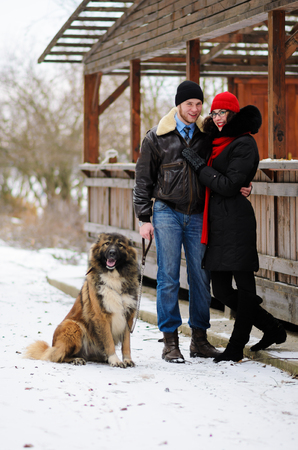 Happy couple with dogs in winter forest. Lovely moments outdoor holidays.の写真素材