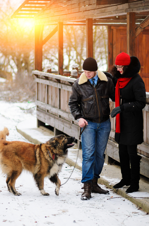 Happy couple with dogs in winter forest. Lovely moments outdoor holidays.の写真素材