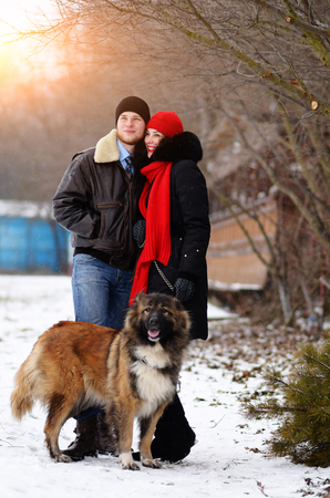 Happy couple with dogs in winter forest. Lovely moments outdoor holidays.の写真素材