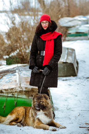 Young woman playing with Caucasian shepherd in a delightful spring dayの写真素材