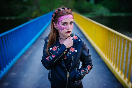 A young beautiful woman with a violet shine on her face standing on the bridge.の写真素材