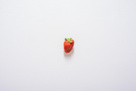 one strawberry fruit on white wood table background.の写真素材