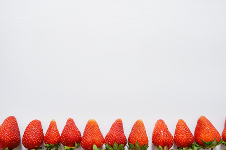 strawberry fruits in a row on white wood table background.の写真素材