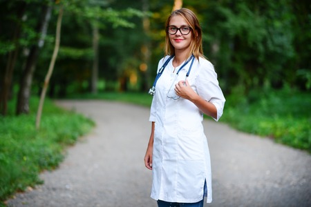 a young girl who is a doctor stands outside, she has crossed her arms on her chest.の写真素材