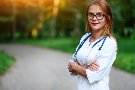 a young girl who is a doctor stands outside, she has crossed her arms on her chest.の写真素材