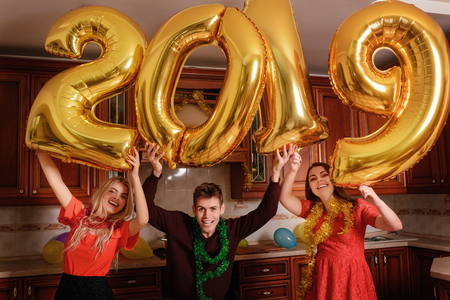 New 2019 Year is coming. Group of cheerful young people carrying gold colored numbers and have fun at the party.の写真素材