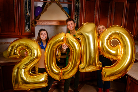 New 2019 Year is coming. Group of cheerful young people carrying gold colored numbers and have fun at the party.の写真素材