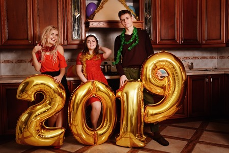 New 2019 Year is coming. Group of cheerful young people carrying gold colored numbers and have fun at the party.の写真素材