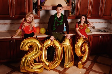 New 2019 Year is coming. Group of cheerful young people carrying gold colored numbers and have fun at the party.の写真素材