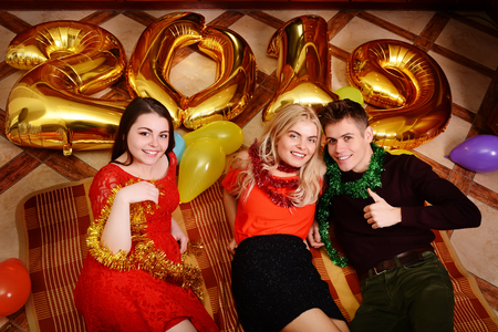 New 2019 Year is coming. Group of cheerful young people carrying gold colored numbers and have fun at the party.の写真素材