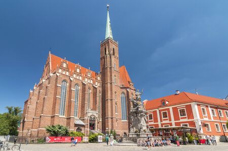 Church of the Holy Cross and St Bartholomew and statue of John of Nepomuk in Wroclaw, Poland.の写真素材