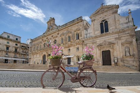 Old fashion bike with flower in front of Town hall (Palazzo Municipale) in the center of Ostuni, Apulia, Puglia, Italy.のeditorial素材