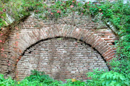 Old wall in a ruin with vegetation aroundの写真素材