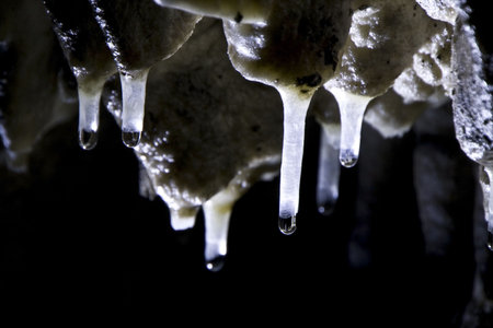 Falling water from little white stalagmites in formationの写真素材