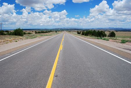 Long asphalt road with a cloudy skyの写真素材