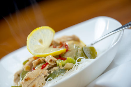 Closeup view of a bowl of thai green curry and rice vermicelli noodles ethnic cuisine
