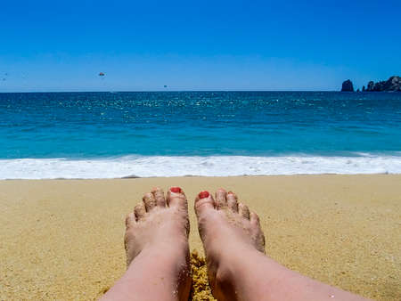 Woman's Feet on Sandy Beach in Sunshineの写真素材