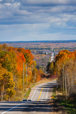 the view down a scenic country roadway in autumn landscapeの写真素材