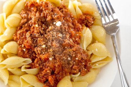 bowl of fresh pasta noodle and bolognese meat and tomato sauce in homestyle meal on bright backgroundの写真素材