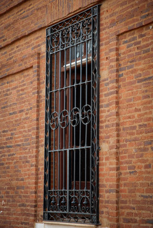 Iron lattice on the wall of a red brick building in the city