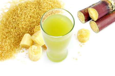 sugar cane juice and fresh sugarcane cut, cane, granulated sugar yellow brown on white backgroundの写真素材