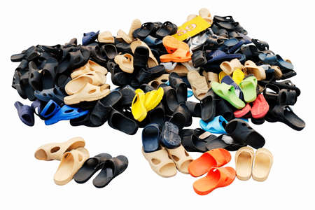 Piles of shoes sold in various color combinations rural land market, sandals, casual shoes, old. isolated on white backgroundの写真素材