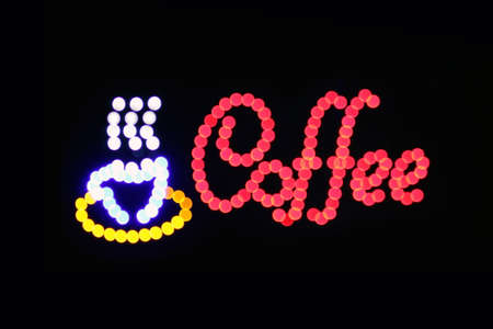 Coffee shop sign LED Bokeh light on dark background, Coffee shop sign Light signage bokeh dot colorful, Sign word coffee cup neon dot light symbol on black backgroundの写真素材