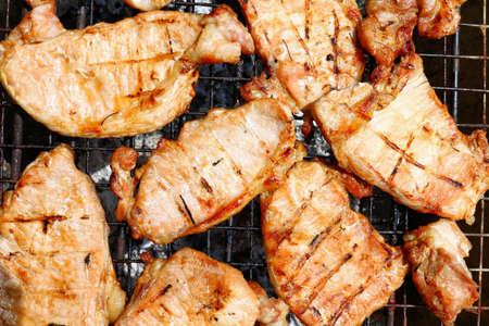 Grilled pork, Barbecue, Grilled BBQ meat food on fireplace grill, Meat meal background cut into grilled pieces top viewの写真素材