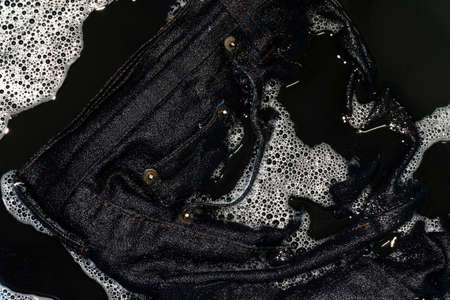 Jeans blue dark soak in sponge washing and wet in sponge water dirty black, Colored jeans clothesの写真素材