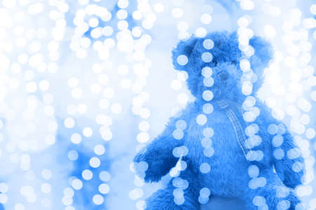 Teddy bear doll in Lighting line bokeh blue white bright for Christmas or happy new year Background, Bear in glitter Green background Blurred bokeh bright (Selective Focus)の写真素材
