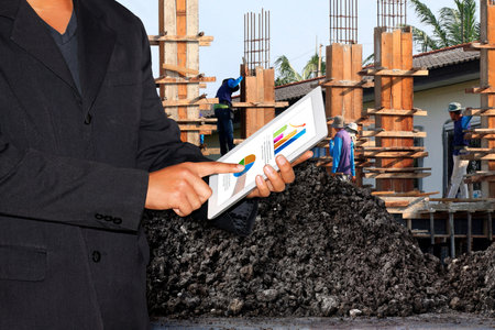 Business Construction Site, Businessman using tablet and Blurred background Construction workers