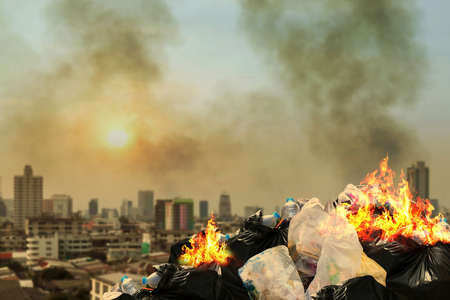 Burn lot waste front City community, Garbage bin pile Dump Lots of junk Polluting Burning heap smoke from burning pile garbage pollution damage Dust, Air pollution burn lot waste smog in cityの写真素材