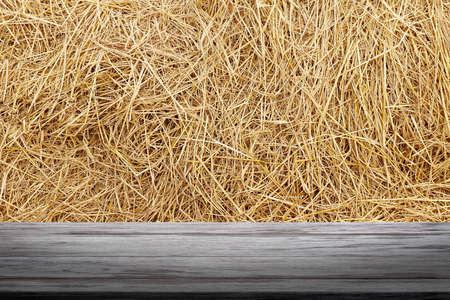 straw backdrop and wood plank, straw wall, straw background texture, wooden floor plank table empty on dry rice straw wall background for copy text spaceの写真素材