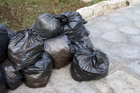 waste lots pile of garbage black bags plastic stack on the floor ground public park, many dump black...