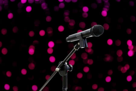 Microphone close up shot on blurred bokeh Purple Pink background beautiful romantic or glitter lights circle soft on dark background, Night Party Singing conceptの写真素材