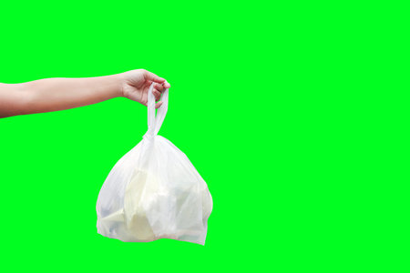 Hand is carrying waste plastic garbage bags isolated on green screen background, Hand holding...